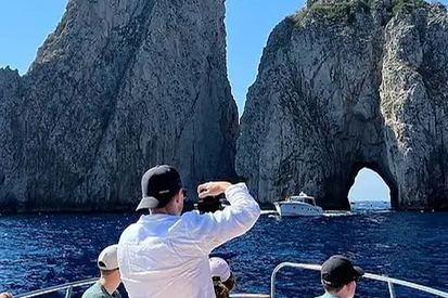 Un barco junto a los Faraglioni de Capri