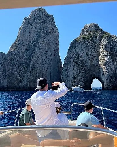 A boat beside the Faraglioni rocks of Capri