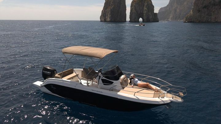 Private boat beside the Faraglioni rocks of Capri