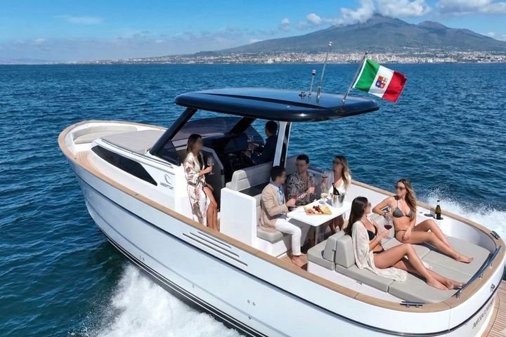 Guests enjoying drinks on the aft deck of the Apreamare Gozzo 35 with Mount Vesuvius in the background