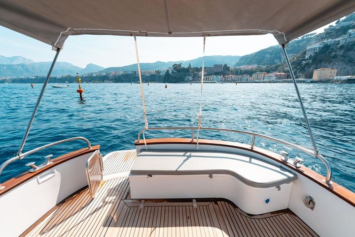 The teak stern cockpit of the Gozzo 30 with the Sorrento coast beyond