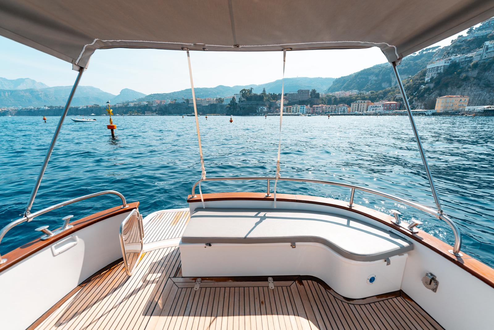 The teak stern cockpit of the Gozzo 30 with the Sorrento coast beyond